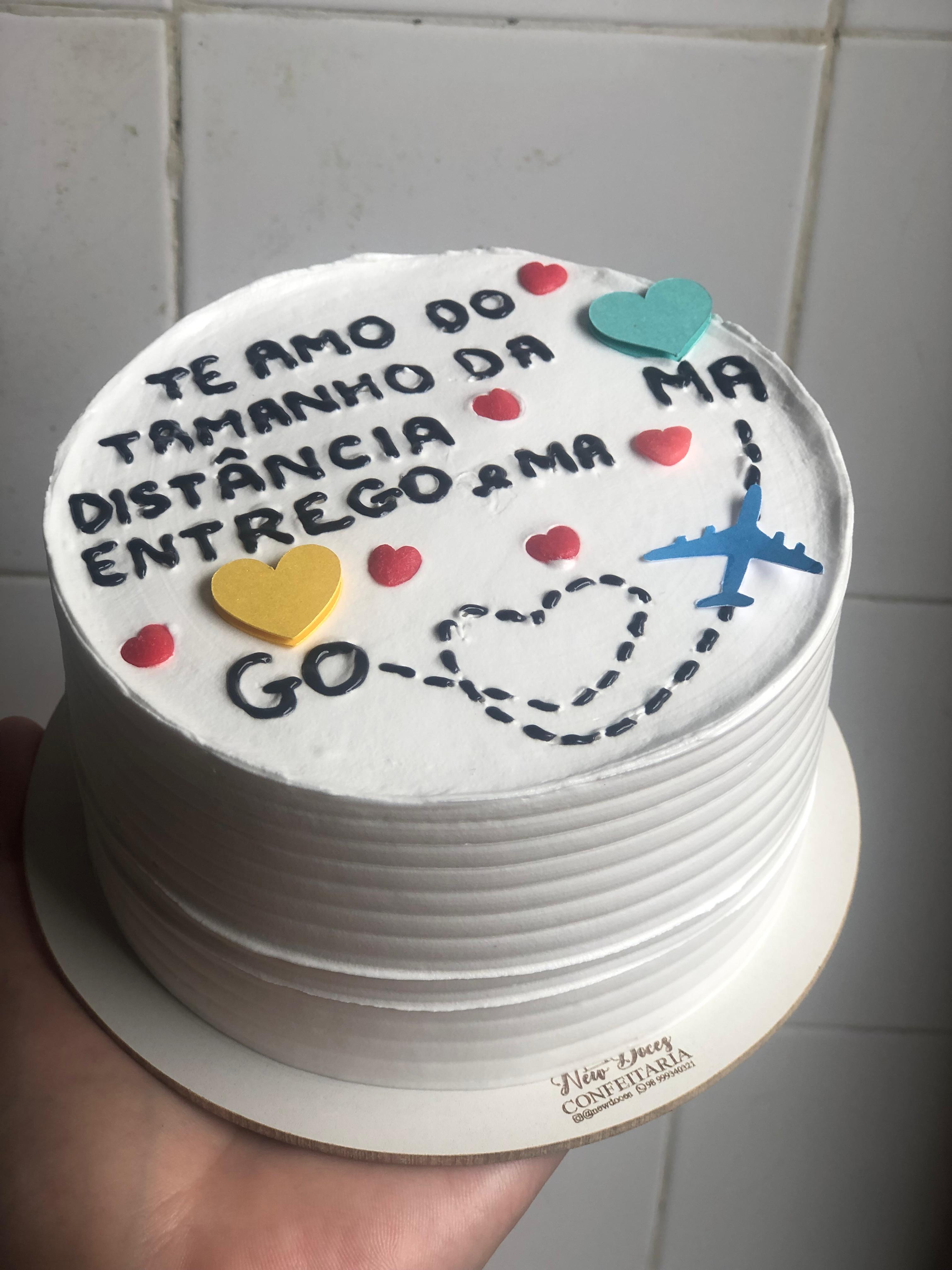 Bolo branco com frase bem-humorada e desenho colorido na cobertura
