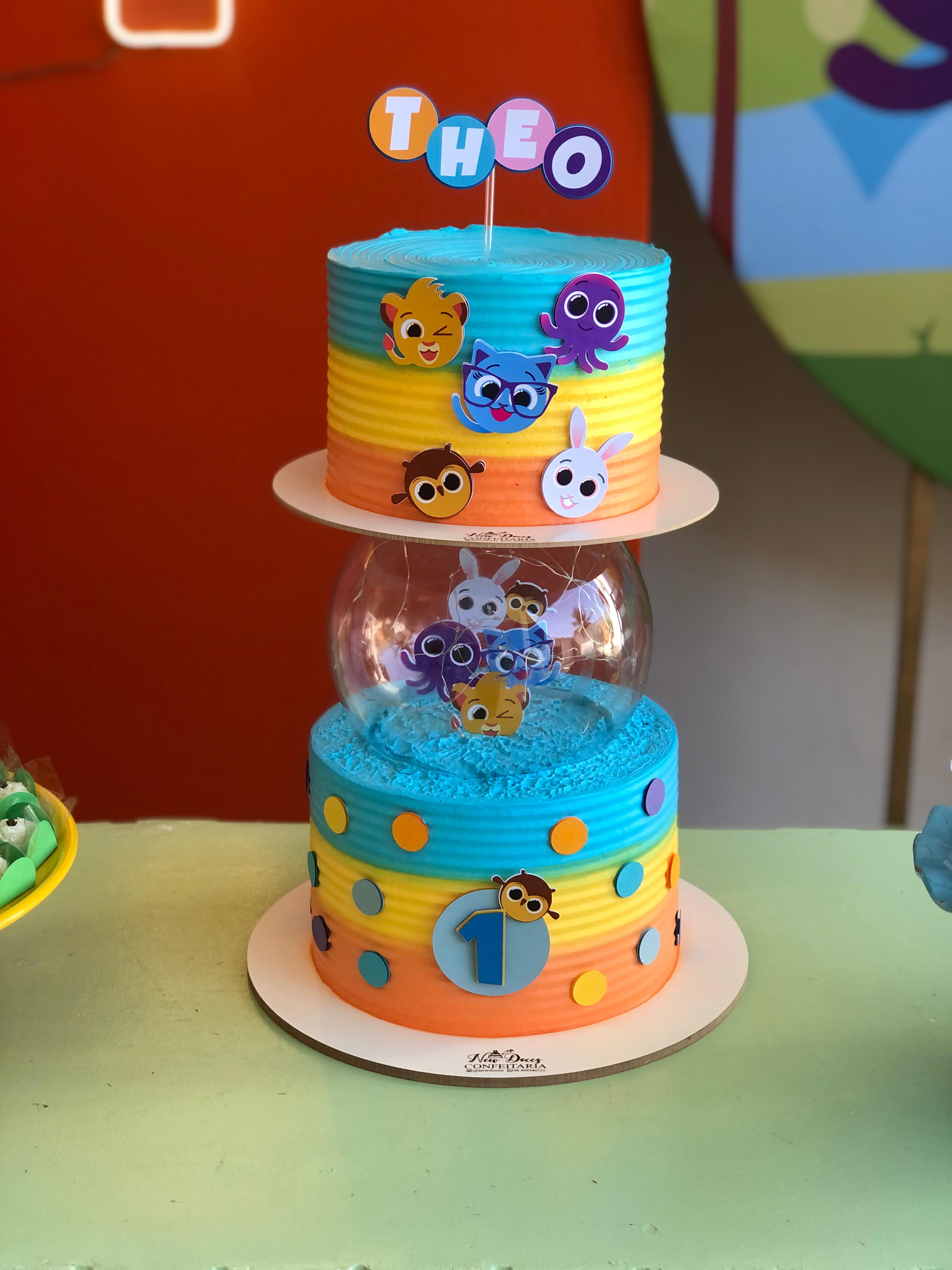 Bolo de dois andares em azul e amarelo com apliques coloridos