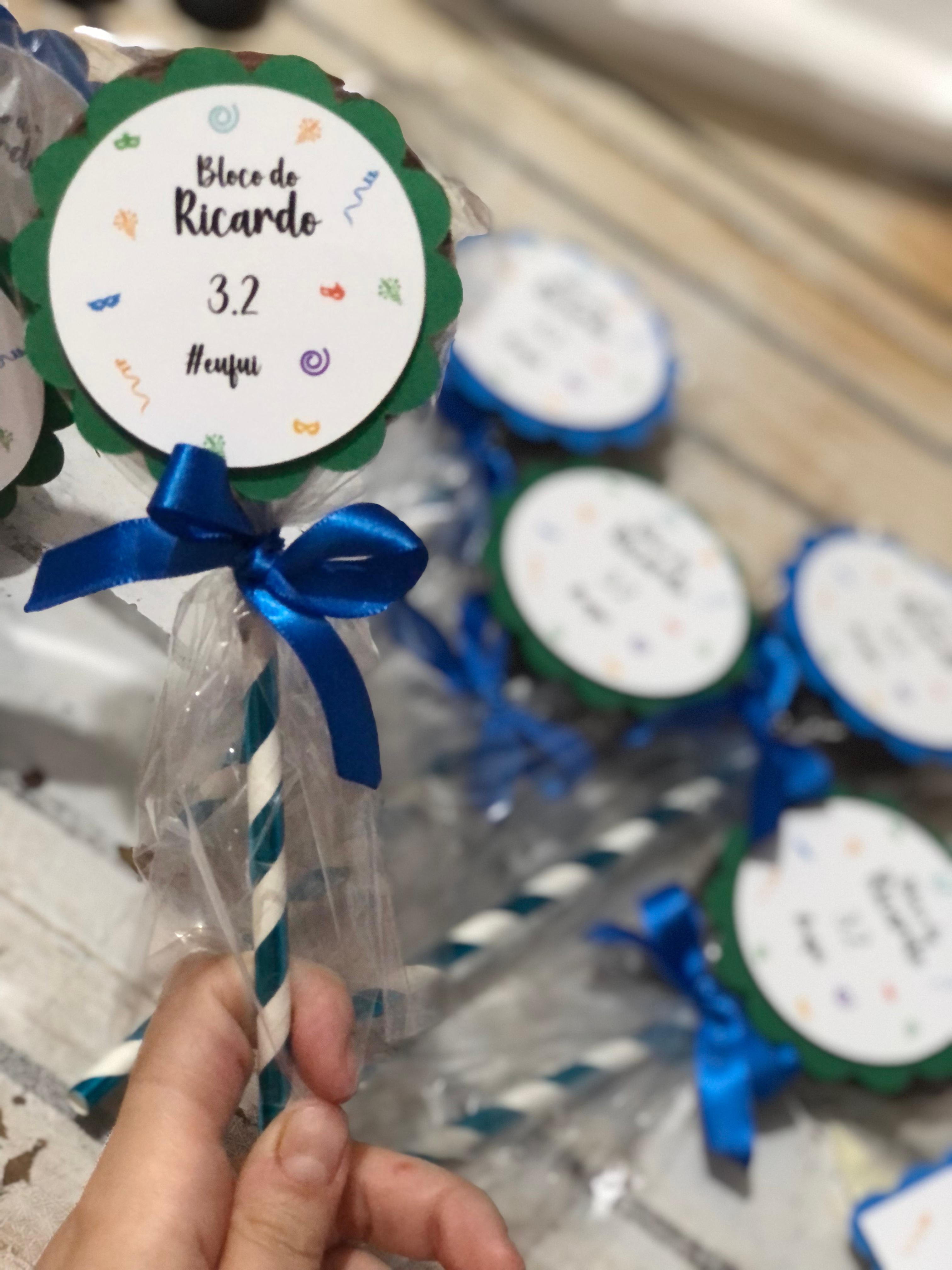 Doces em palito embalados individualmente com etiquetas e laços azuis