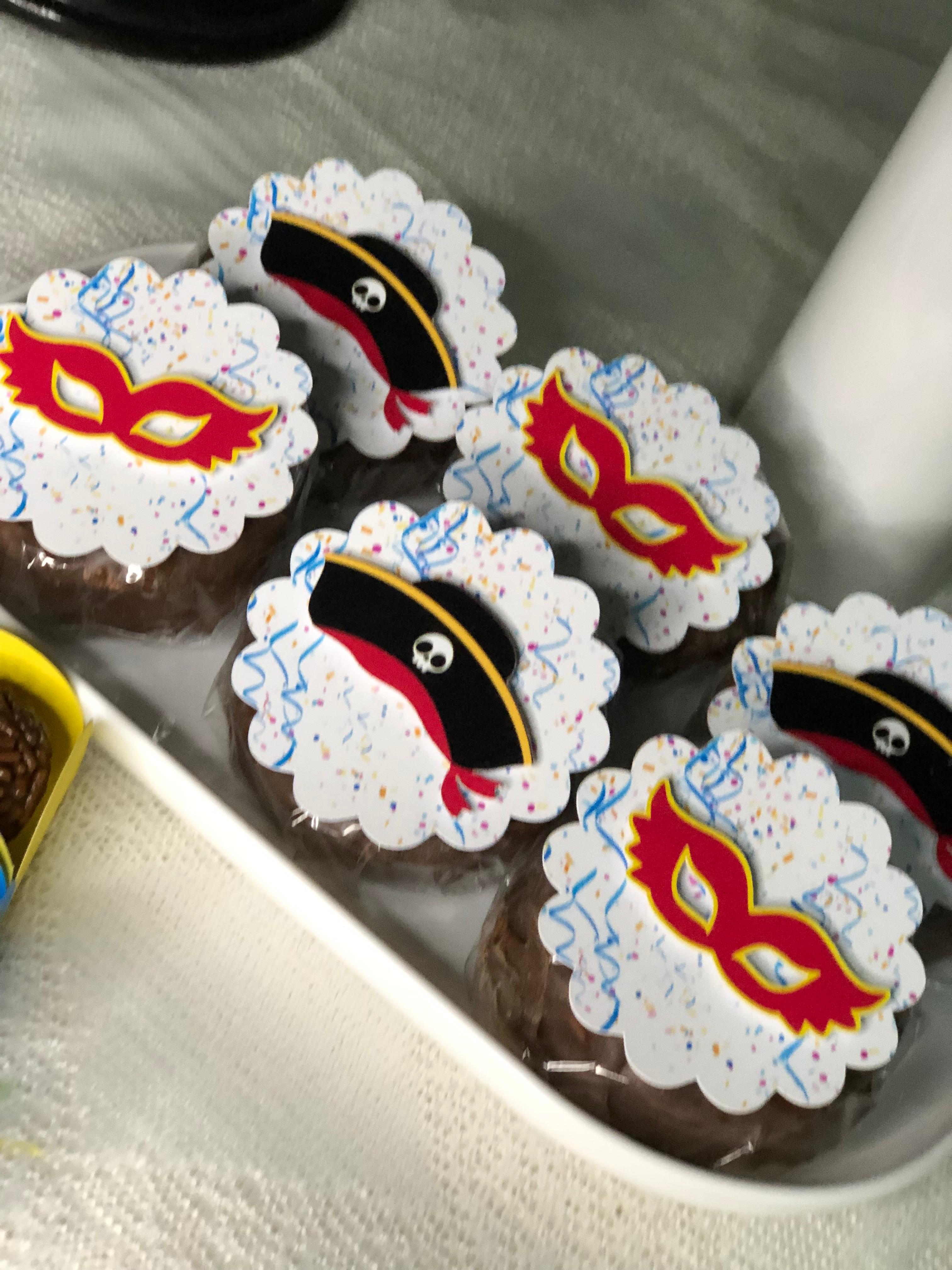 Cupcakes com cobertura branca e apliques decorativos vermelhos e pretos
